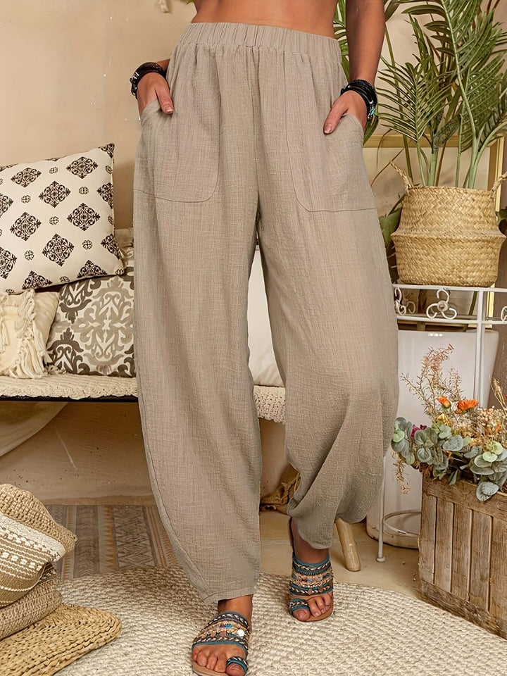 Breathable khaki women's linen trousers with elastic waist and pockets, perfect for resort wear.