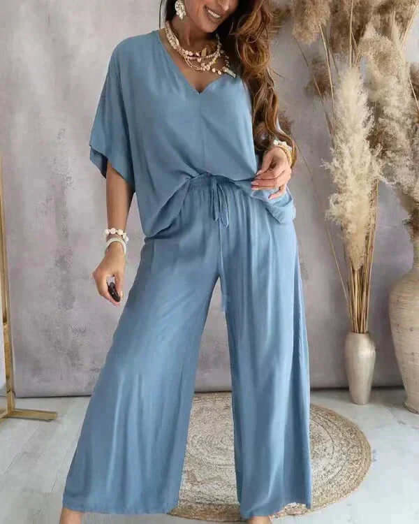 Comfortable women's two-piece loungewear set with V-neck top & wide-leg pants, perfect for relaxing at home.