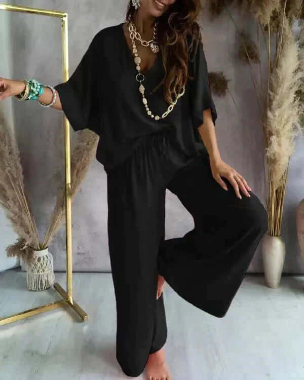 Woman wearing a relaxed fit loungewear set, V-neck top & wide-leg pants, showcasing ultimate comfort & casual style.