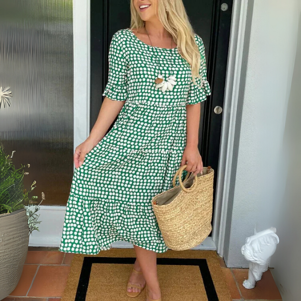 Woman wearing a chic relaxed tiered midi dress, perfect for casual outings or an elegant summer look.