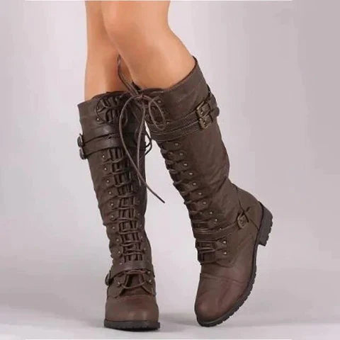 Close-up of women's faux leather lace-up knee-high boots with buckle details.