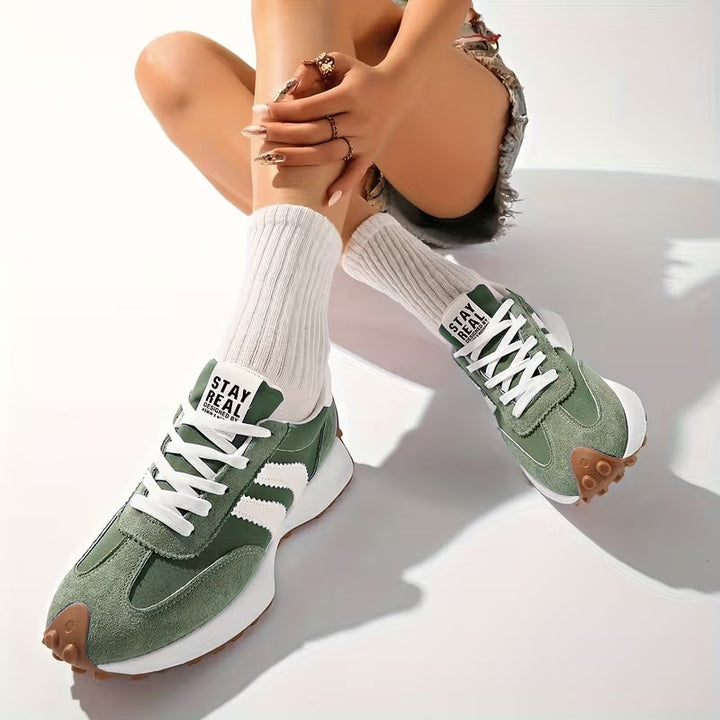 Side view of women's vintage style platform trainers, featuring a thick sole and classic lace-up front.