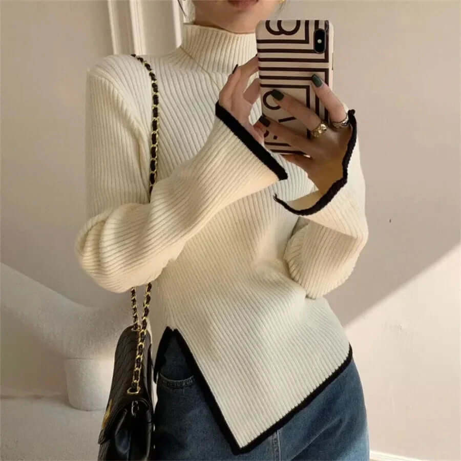 Elegant women's ribbed turtleneck sweater with dramatic flared sleeves and an asymmetrical hem for fall/winter.