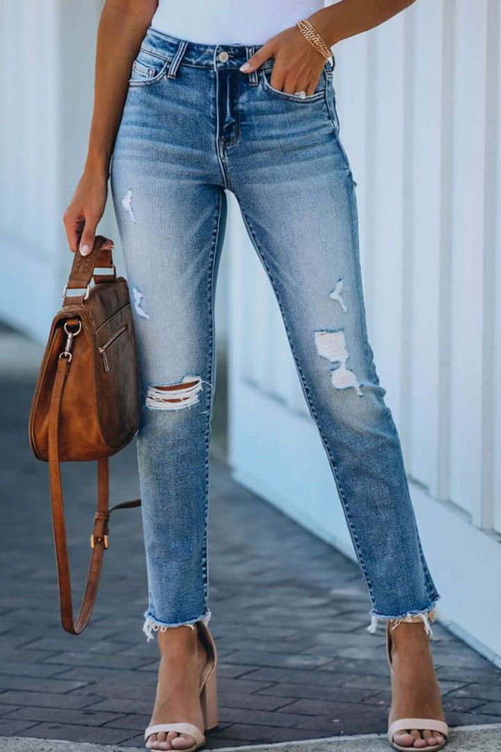 Women's ripped straight leg blue denim jeans. Trendy, comfortable, distressed casual wear for everyday.