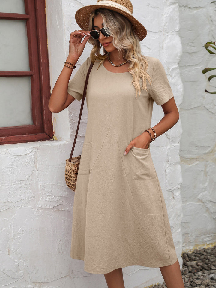 Model wearing a stylish short sleeve A-line midi dress with pockets, showcasing its casual appeal.