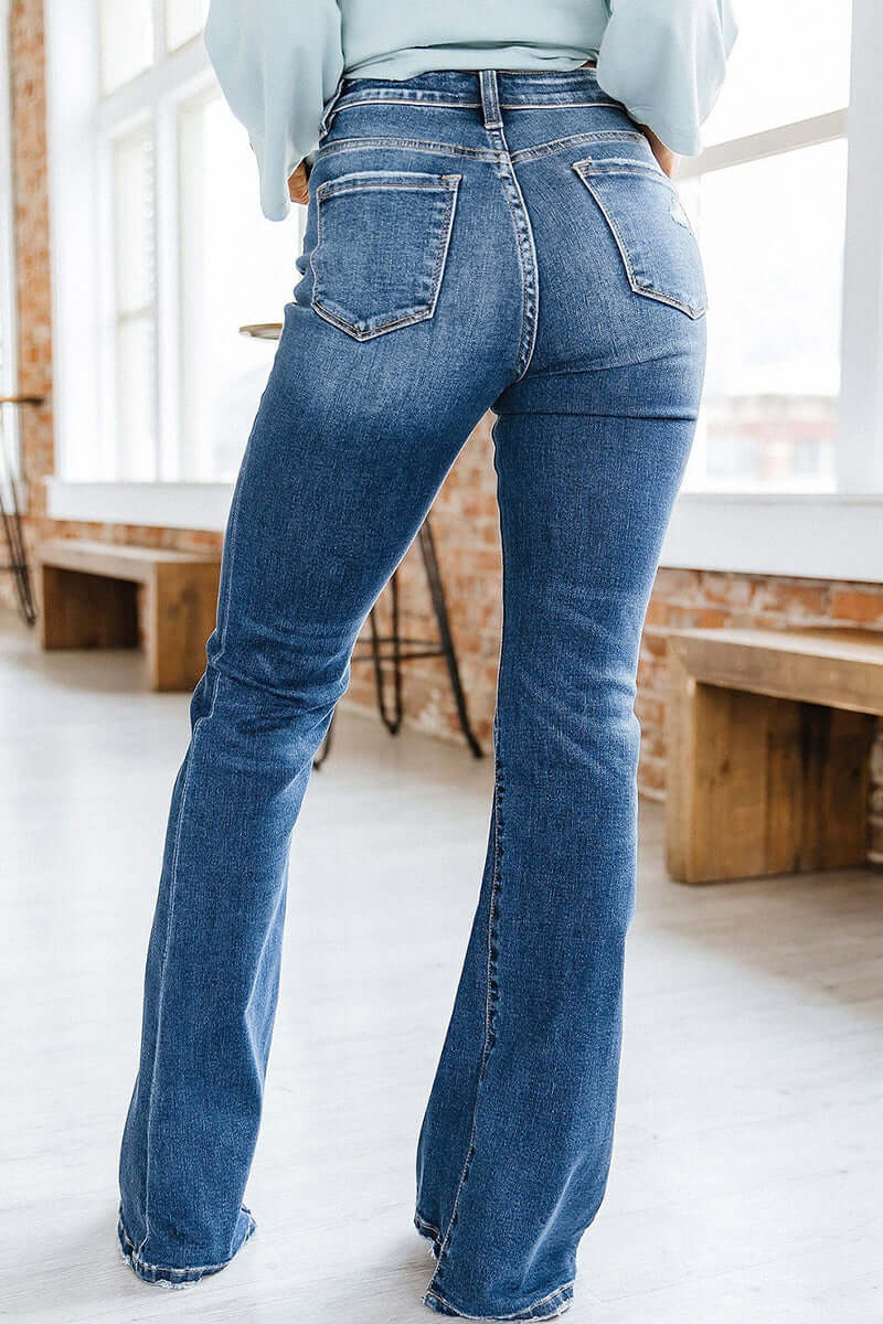 Stylish women's blue flared jeans with a flattering high waist and slim fit, embracing retro denim fashion.