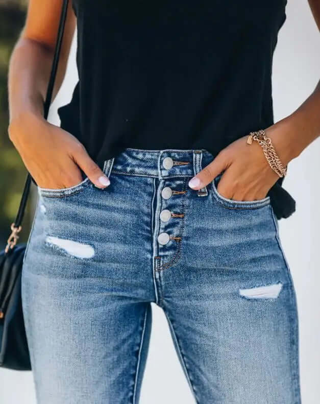 Edgy distressed women's slim fit jeans in blue denim, showcasing stylish rips and a comfortable, modern design.