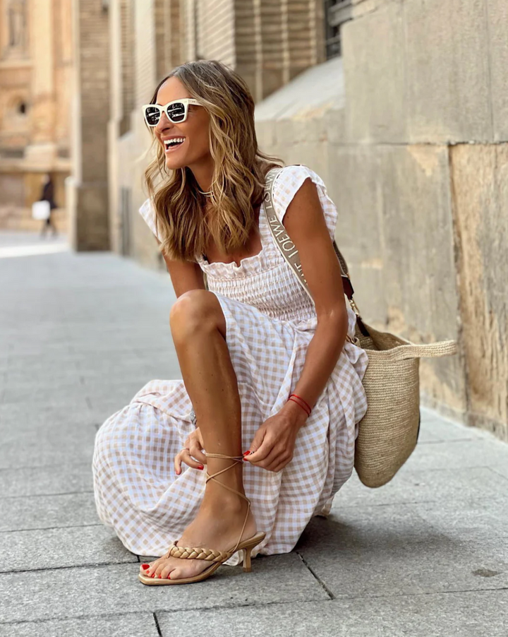 Chic women's flowy gingham maxi dress, smocked bodice & ruffle sleeves, ideal for casual summer or vacation.