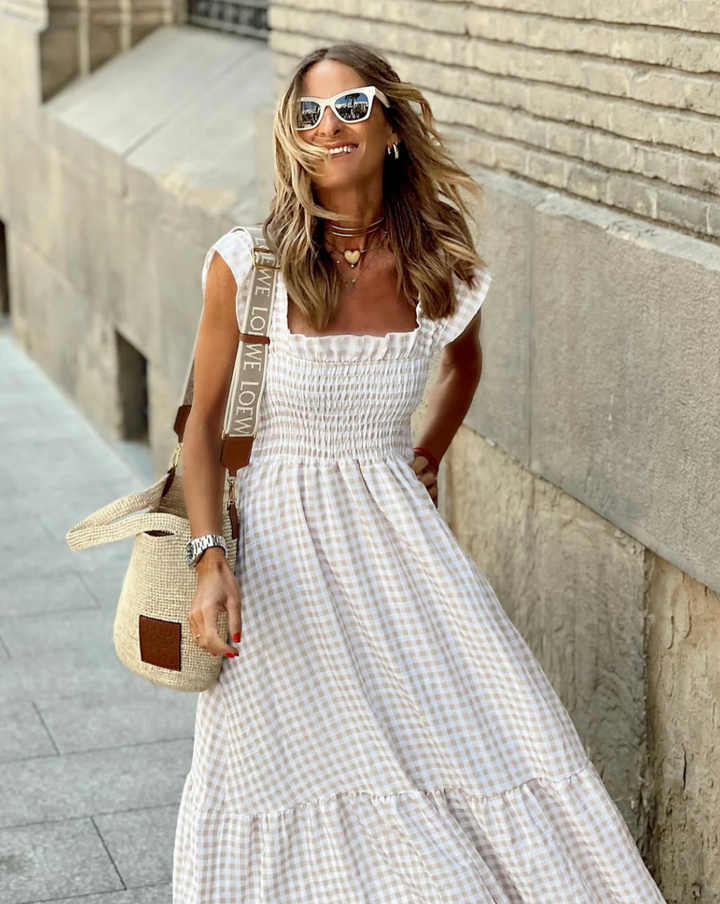 Elegant smocked gingham maxi dress for women, featuring stylish ruffle sleeves & a comfortable, flowy design.