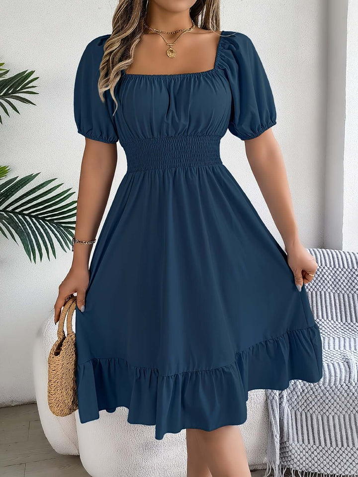 Stylish women's smocked midi dress with fashionable puff sleeves and a comfortable A-line fit.