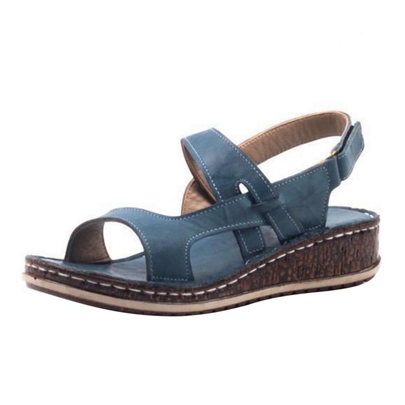 Close-up of women's strappy wedge sandals showing detailed cork-look sole and straps