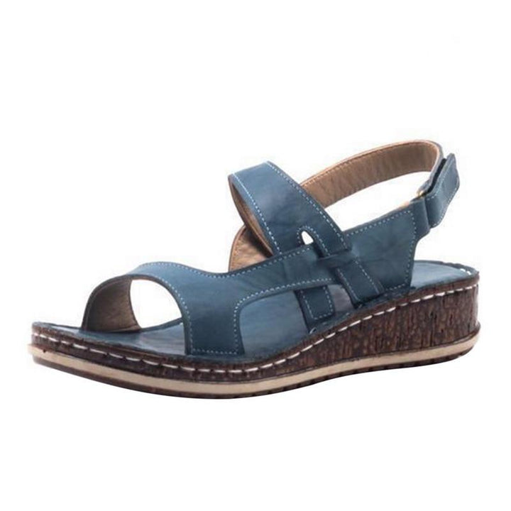 Close-up of women's strappy wedge sandals showing detailed cork-look sole and straps