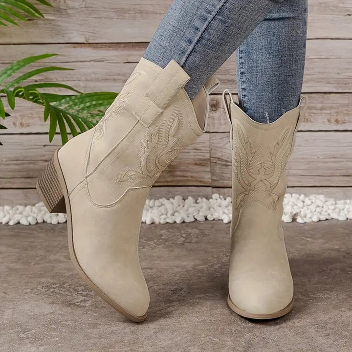 Beige women's heeled western boots, versatile ankle/mid-calf cowgirl style with decorative stitching.