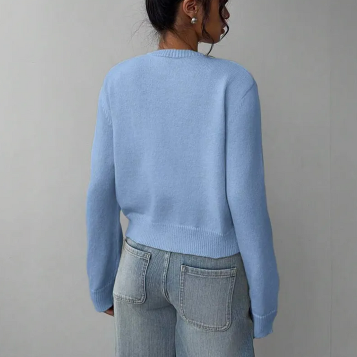 Modern women's cropped cardigan. Features ribbed trim & easy button closure.