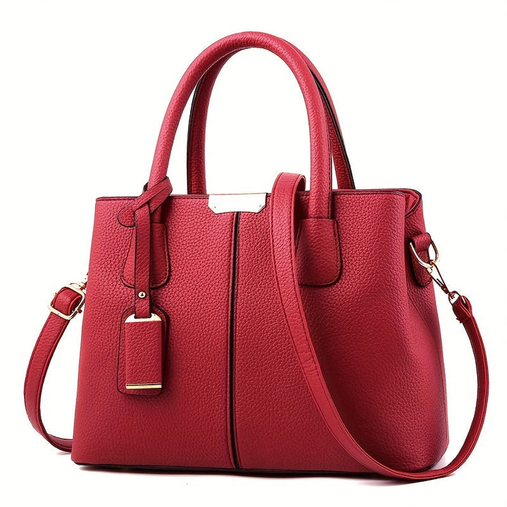 Woman wearing a modern leather shoulder bag, showcasing its elegant design and practical size.