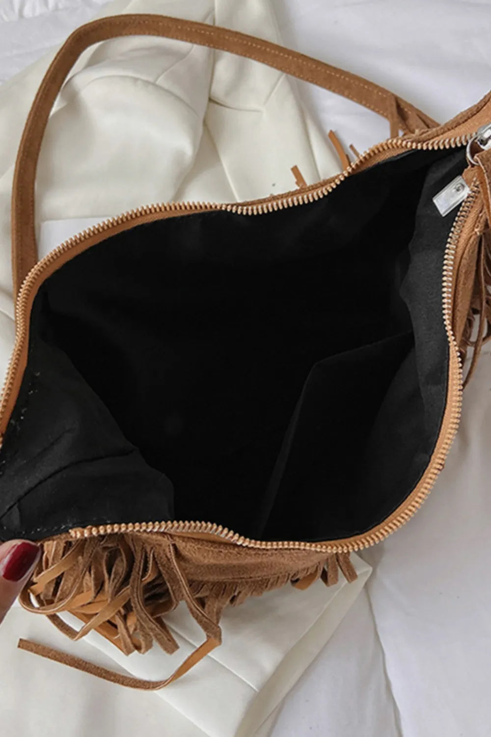 Womens boho suede bag with flowing fringe and an adjustable crossbody strap.
