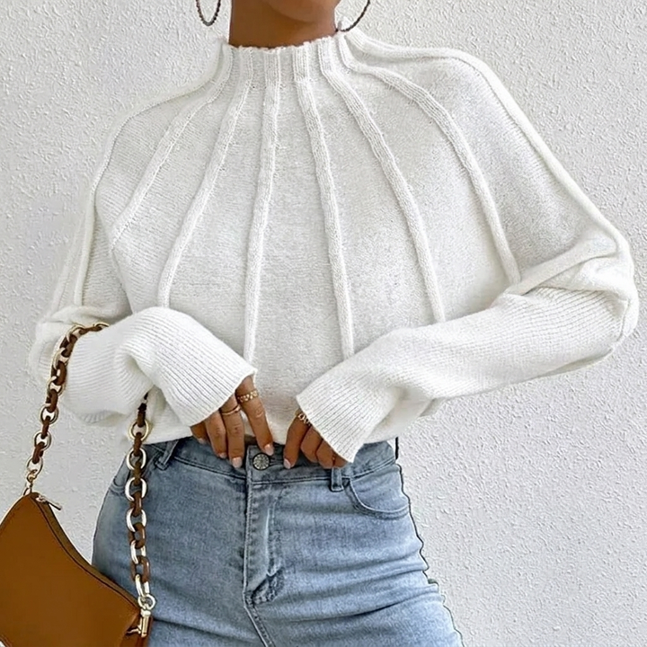 Women's sunburst design jumper with mock neck and batwing sleeves. Perfect for casual chic winter style.