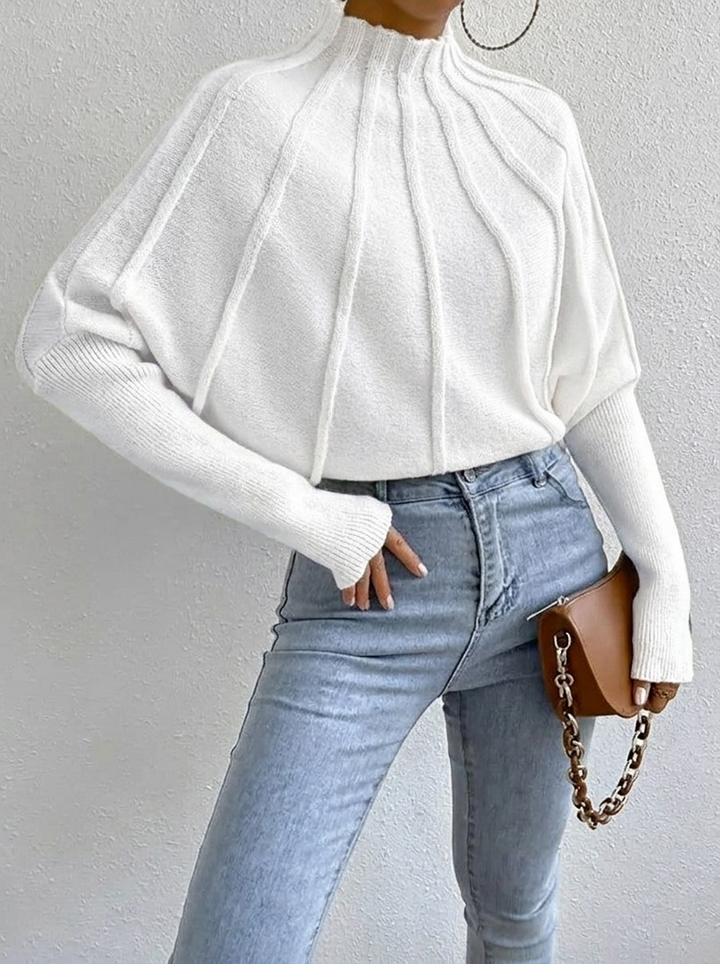 Elegant women's batwing sweater with a distinct sunburst pattern and comfortable mock neck, winter fashion.