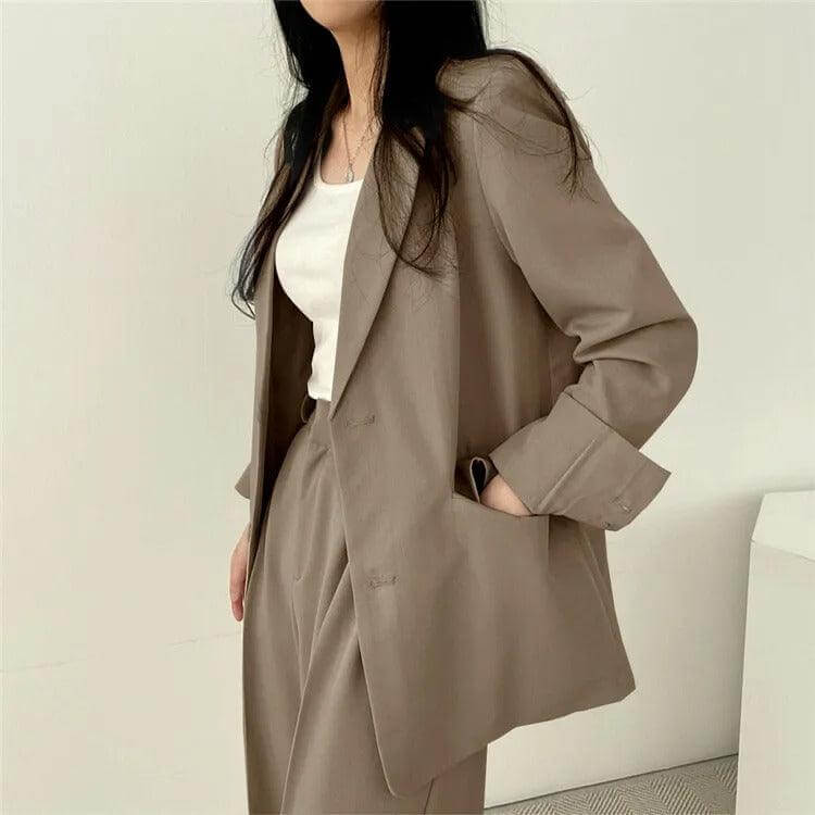Modern women's professional outfit: tailored blazer and straight-leg pants suit.