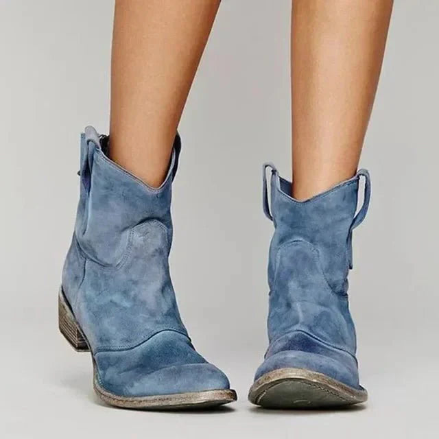 Close-up of a women's brown suede western boot, highlighting the texture and block heel design.