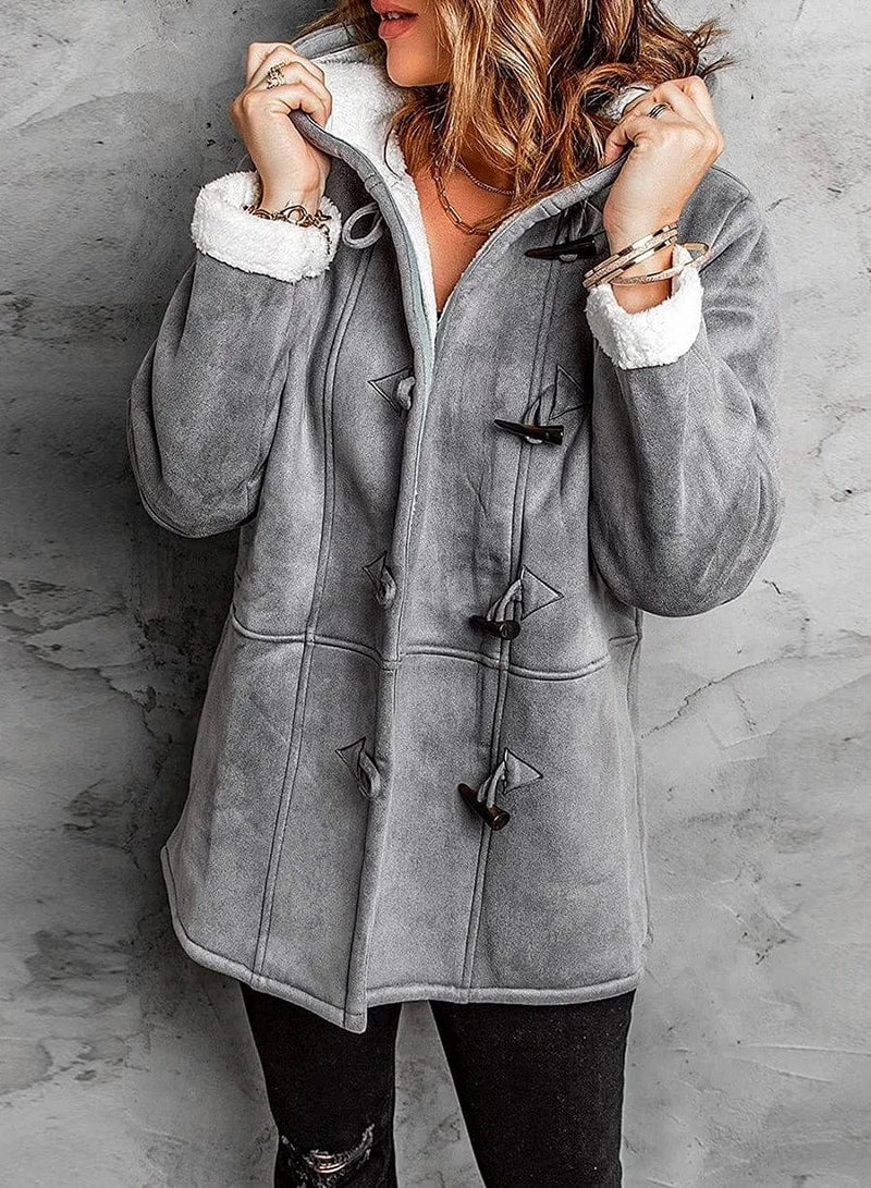 Woman wearing a warm hooded winter coat, perfect for outdoor activities and stylish cold weather outerwear.