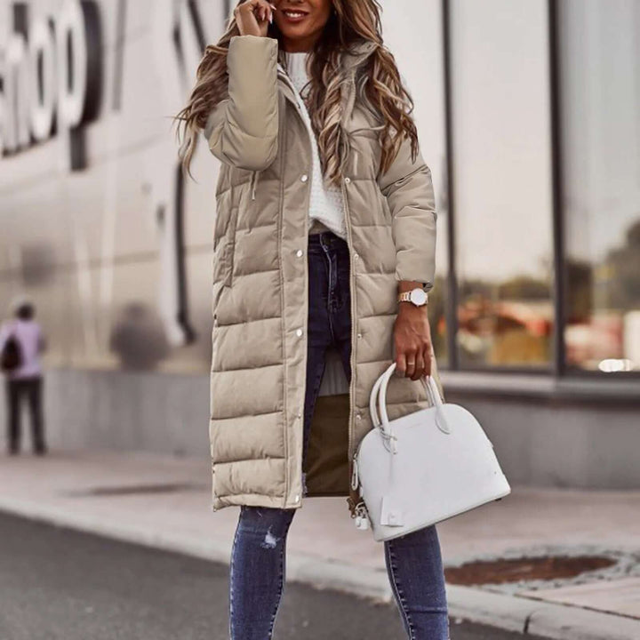 Fashionable women's padded long winter coat with a protective hood, perfect for winter style.