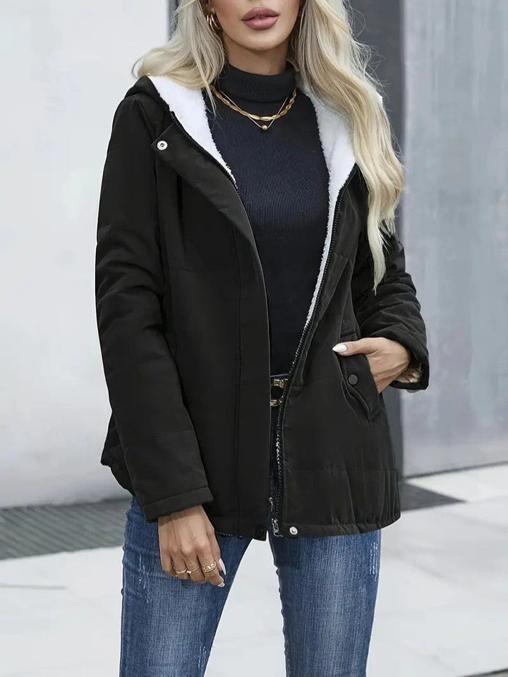 Women's sleek zip-up hooded jacket, warm and versatile for winter activities.