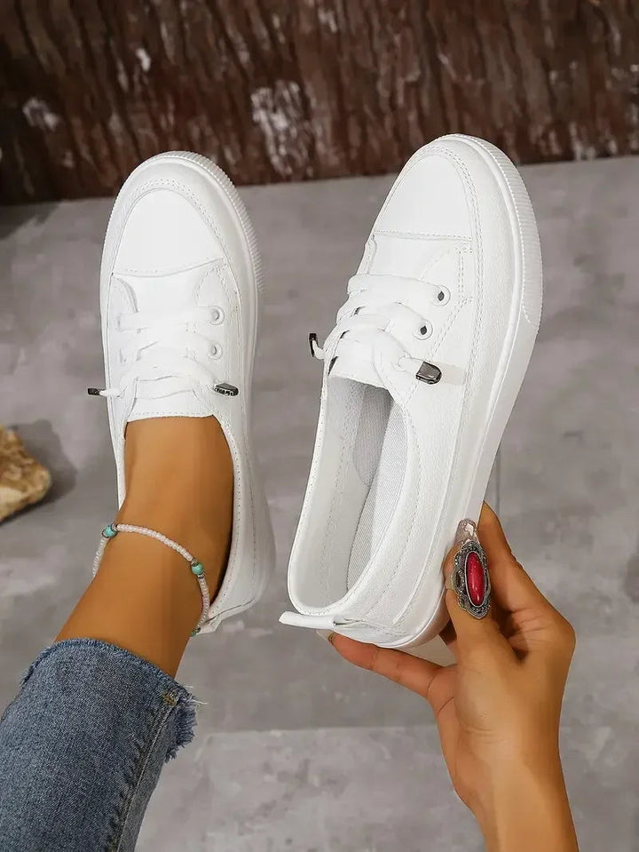 White casual lace-up flat sneakers for women, designed for all-day comfort and versatile everyday styling.