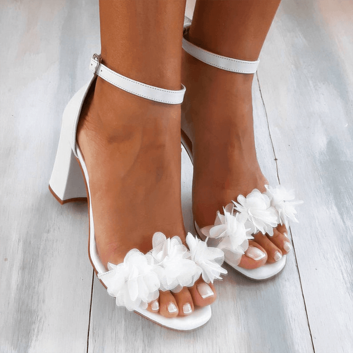 Women's white floral block heel wedding shoes with secure ankle strap, perfect for bridal or special occasions.