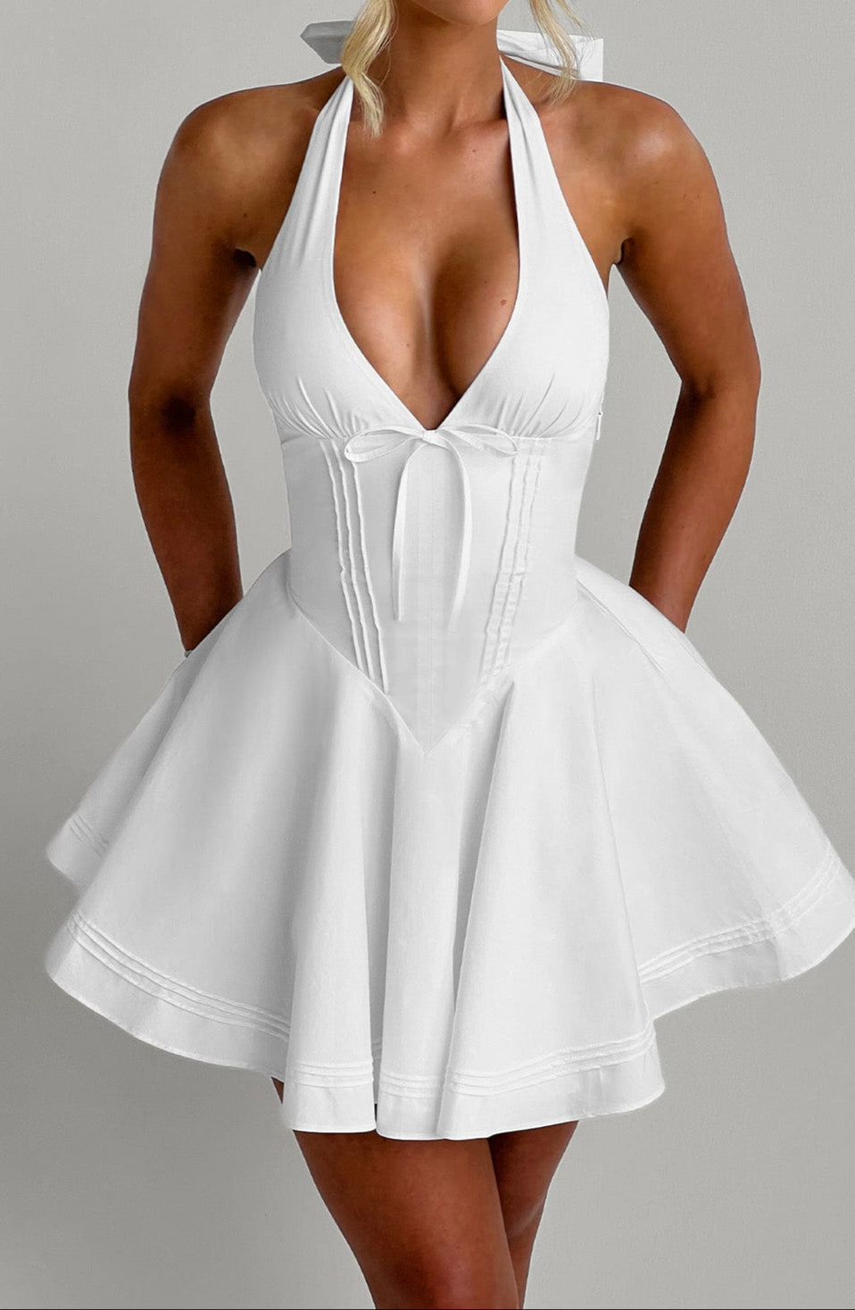 Sophisticated white mini dress, featuring a halter neck for a stylish summer party look.