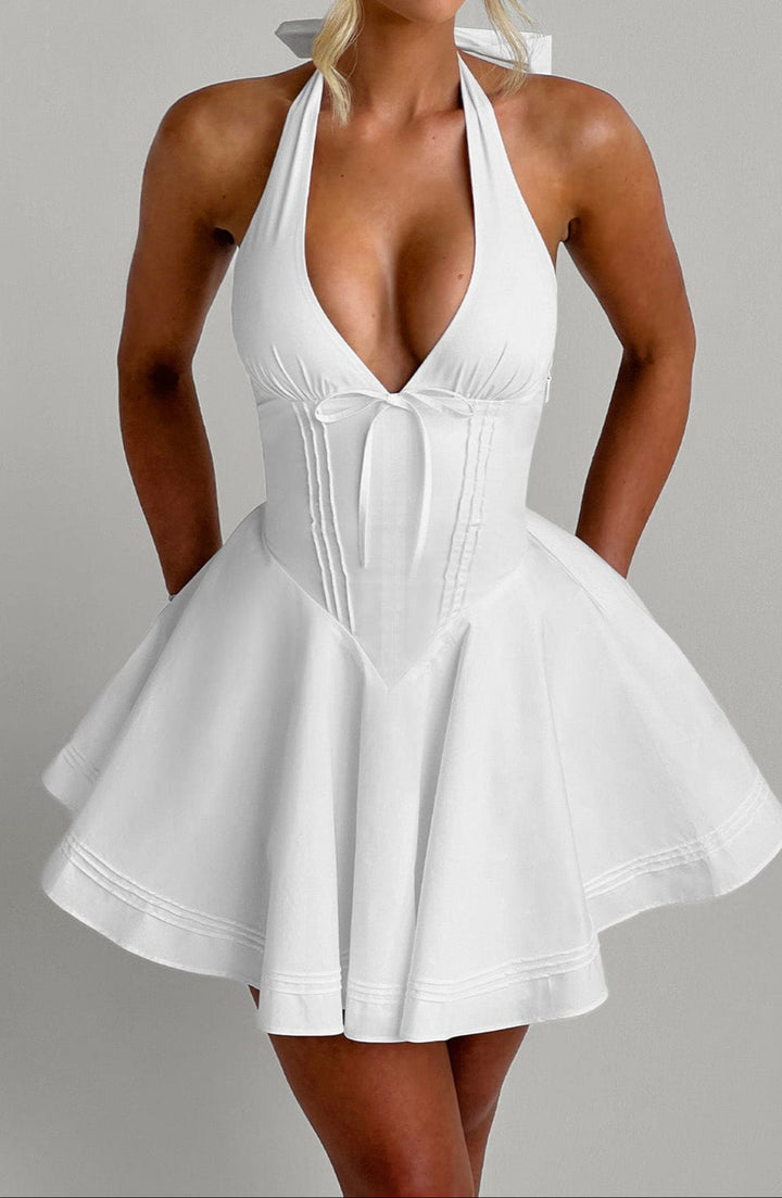 Sophisticated white mini dress, featuring a halter neck for a stylish summer party look.