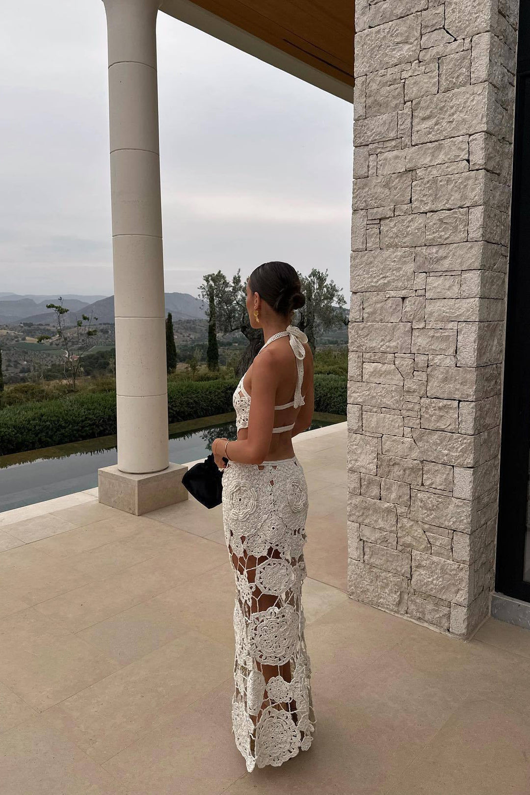 Elegant women's white halter neck maxi dress with intricate cut outs, ideal for summer resort wear & parties.