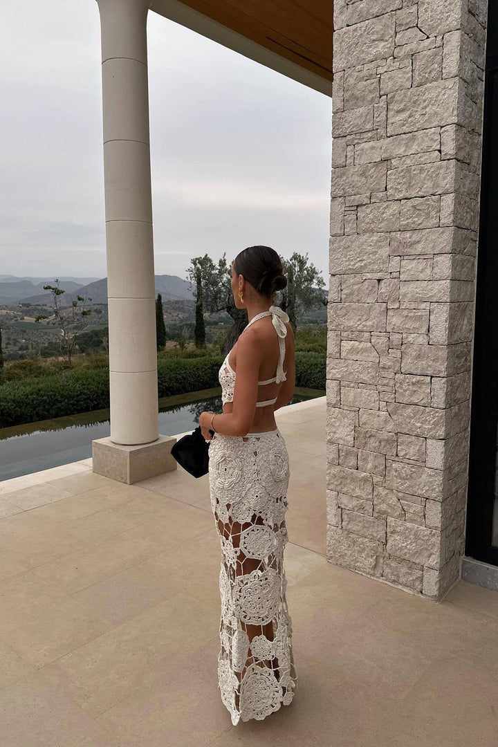 Elegant women's white halter neck maxi dress with intricate cut outs, ideal for summer resort wear & parties.