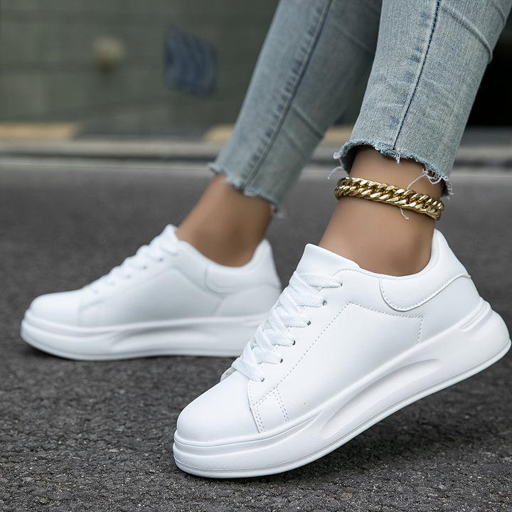 Detail of stitching on women's white sneakers, highlighting quality for comfortable everyday wear.