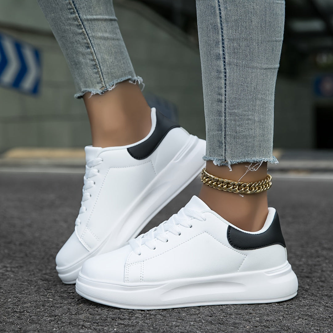 Side view of women's white leather sneakers, perfect for casual wear & versatile everyday style.