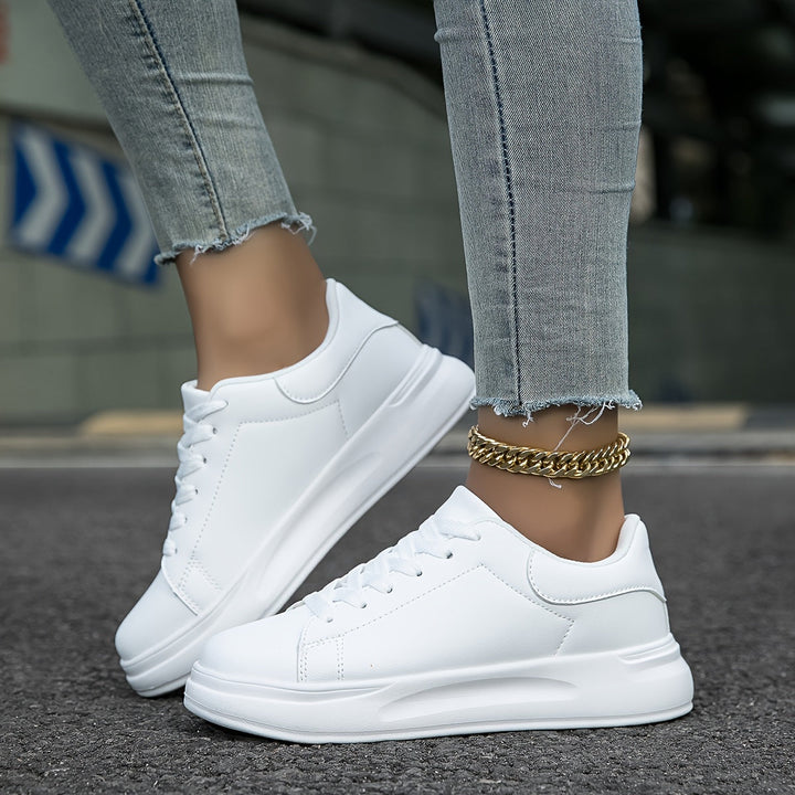 Durable sole of women's white sneakers, providing comfort & grip for walking and everyday wear.