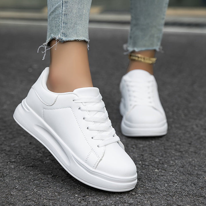 Detail of white laces on women's casual sneakers, enhancing minimalist style & secure fit for walking.