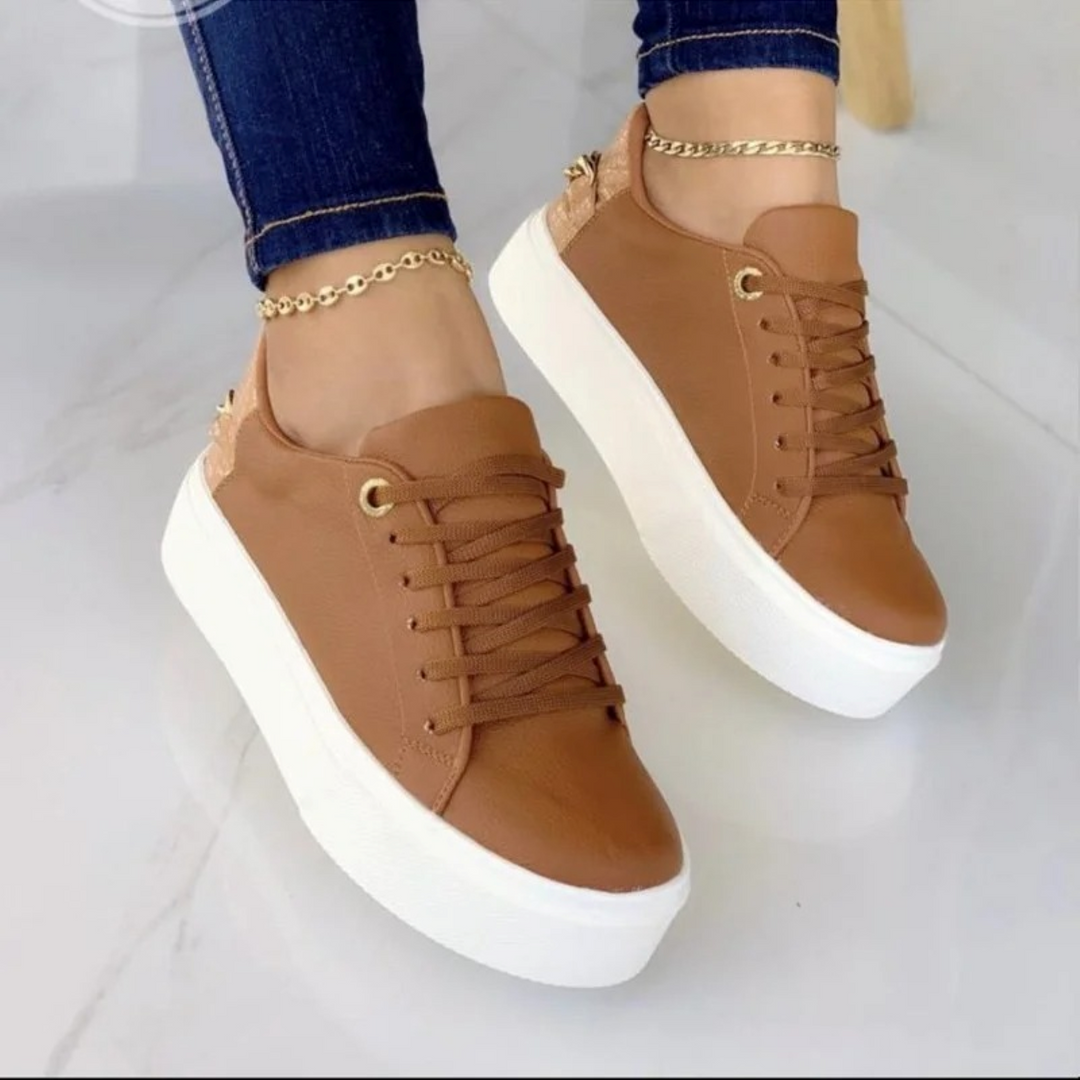 Stylish white leather sneakers for women featuring a chic metallic chain. Perfect for modern casual wear.