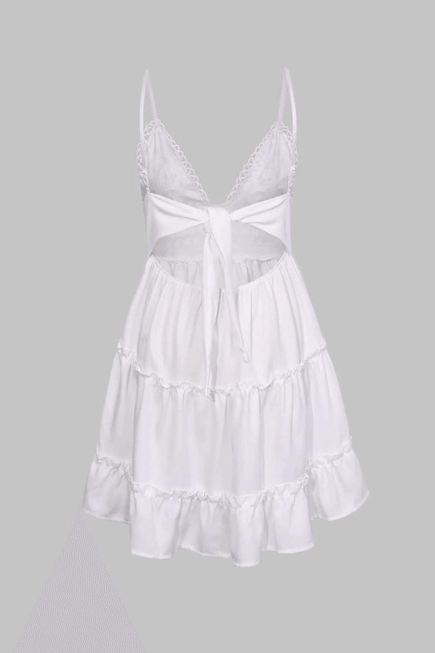 Flowy white mini dress with V-neck and ruffled hem, ideal for a comfortable summer beach or day look.