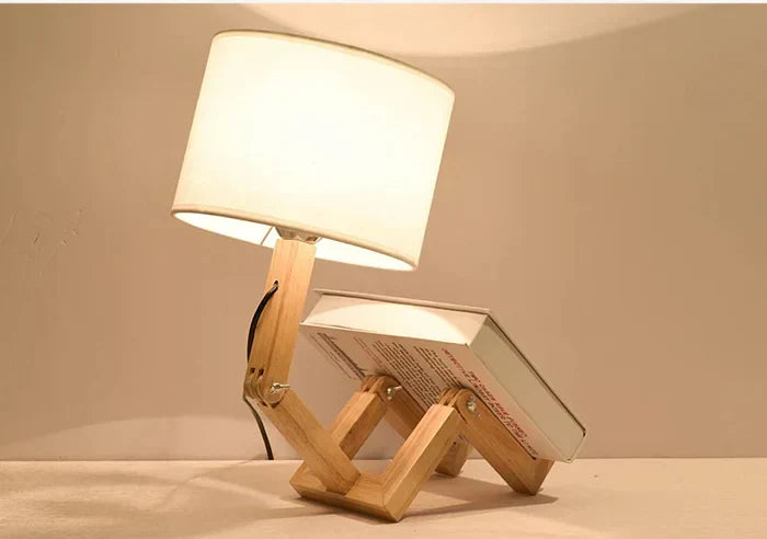 Wooden robot table lamp with adjustable body & integrated book holder. Modern desk lighting.