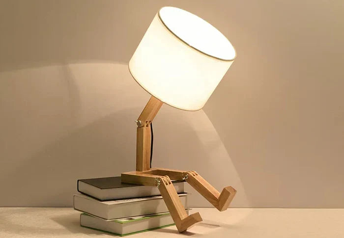 Modern wooden desk lamp, robot design, fabric shade & convenient book holder. Unique lighting solution.