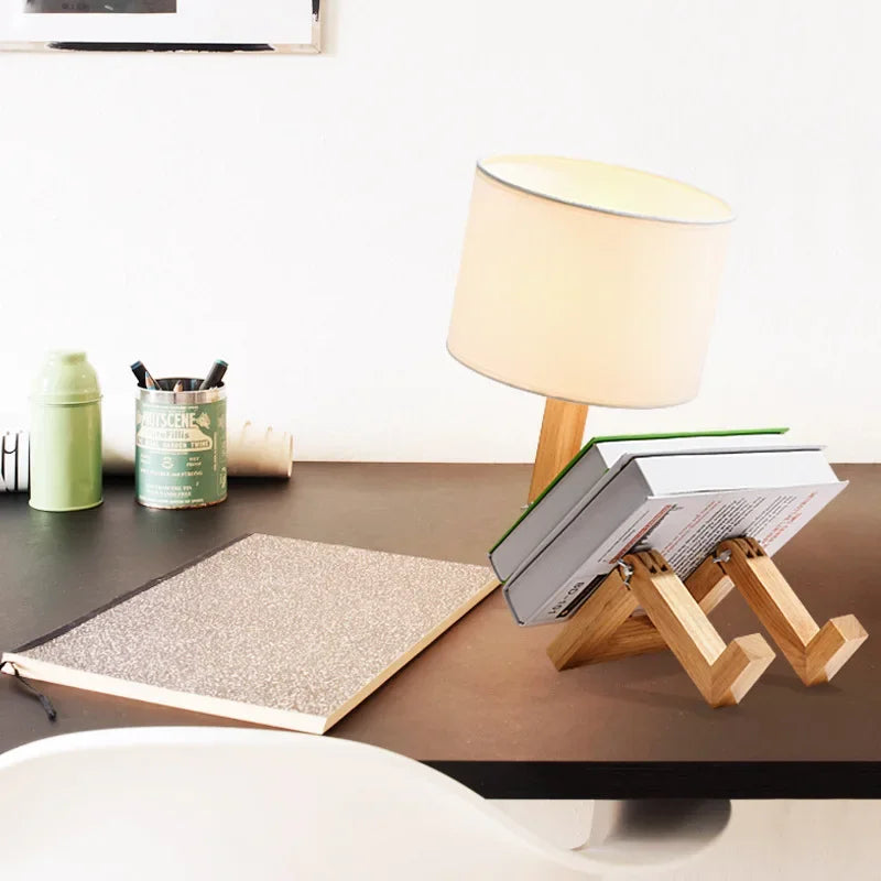 Handcrafted wooden robot desk lamp with a flexible body and practical book holder. Unique home decor.