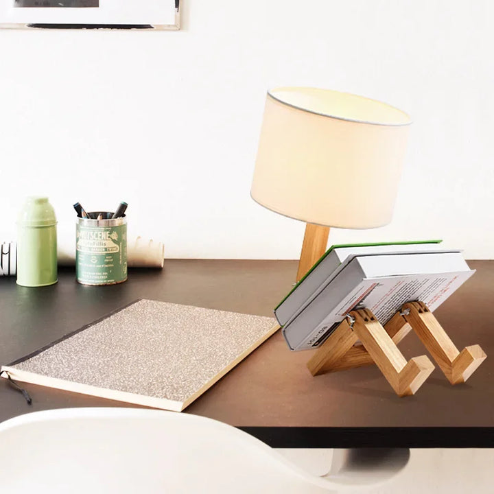 Handcrafted wooden robot desk lamp with a flexible body and practical book holder. Unique home decor.