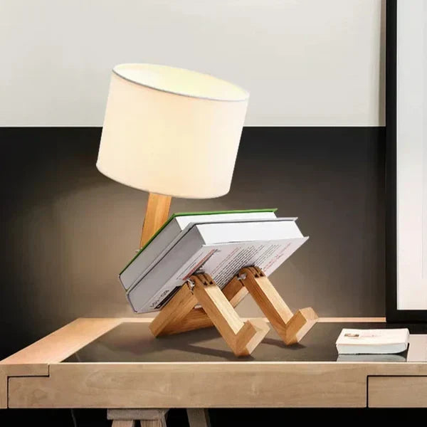 Charming wooden robot lamp with a fabric shade, a flexible body & an integrated book rest. Desk essential.